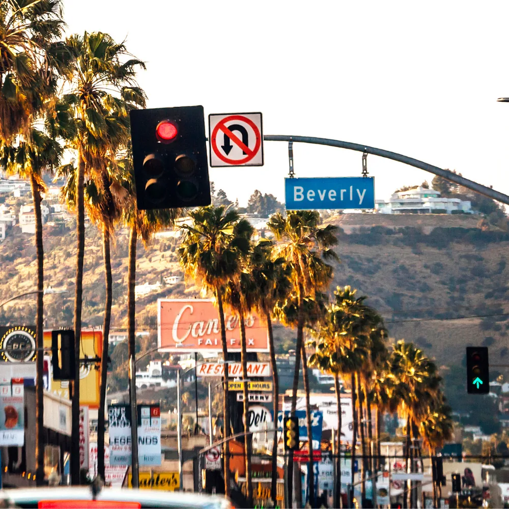Los Angeles, Estados Unidos, avenida com palmeiras e colinas ao pôr do sol